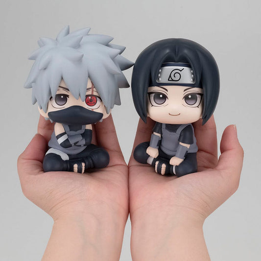 Naruto: Shippuden Look Up series figures of Kakashi Hatake and Itachi Uchiha in Anbu Black Ops version, both seated and looking upward, with distinct character details like Kakashi's eye mask and Itachi's sharingan, accompanied by a special gift in the set.