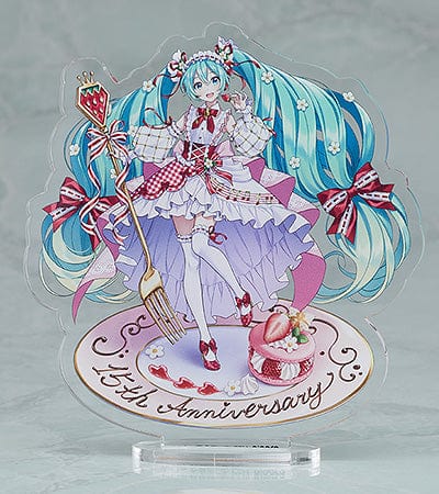 “Nendoroid No.1939 Hatsune Miku (15th Anniversary Ver.) re-run—teal twin-tails with daisies and red bows, frilly dress, holding a strawberry and gold fork, macaron on plate base.”

