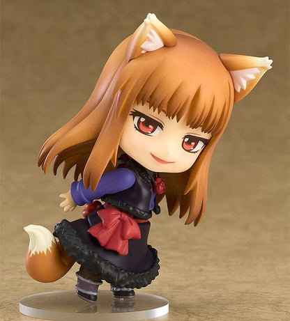 Spice and Wolf Nendoroid No.728 Holo reissue, featuring the harvest deity with amber hair and fox ears, holding a red apple, adorned in a crimson bow and a violet and black dress with a fluffy skirt.