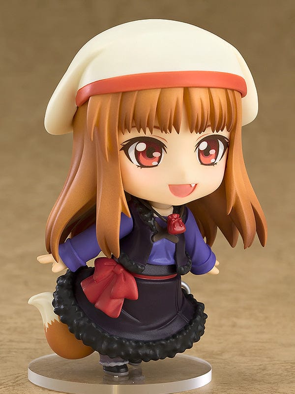 Spice and Wolf Nendoroid No.728 Holo reissue, featuring the harvest deity with amber hair and fox ears, holding a red apple, adorned in a crimson bow and a violet and black dress with a fluffy skirt.