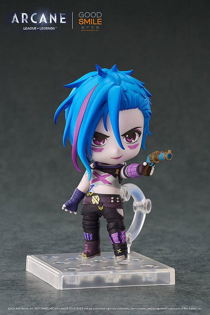 Nendoroid Jinx (Arcane Ver.) from League of Legends: Arcane, showcasing her iconic blue hair, purple outfit, and detailed weapon, posed with a confident grin.