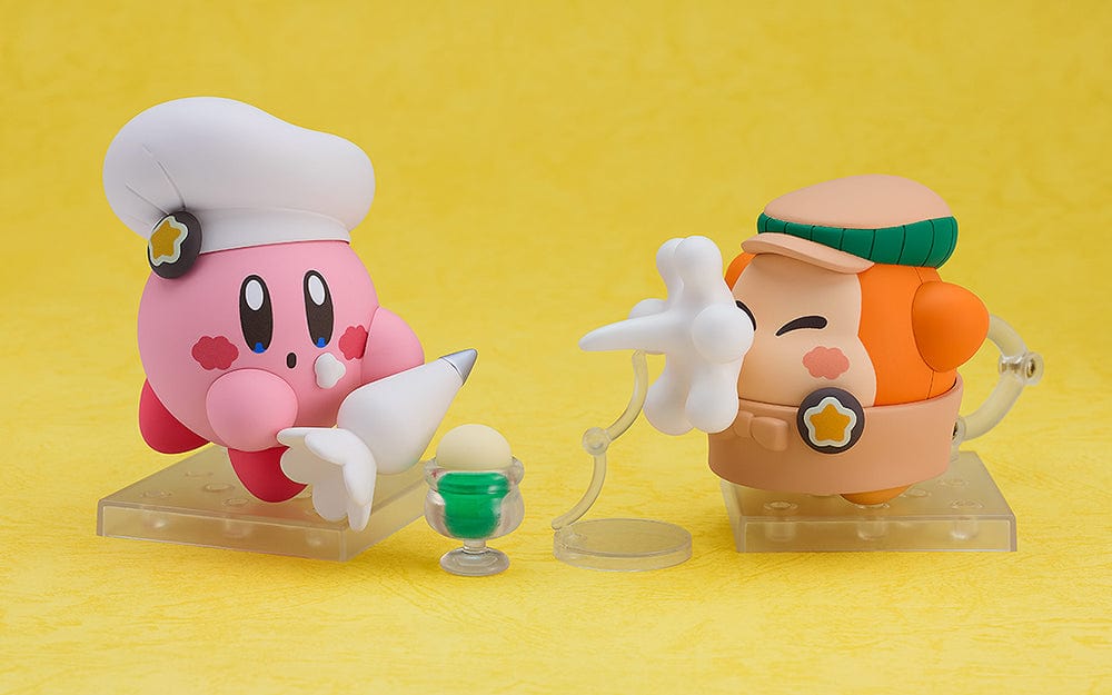 Kirby Nendoroid No.2598 (Cafe Ver.) dressed as a chef, holding a fork, with a green Kirby Café signboard.