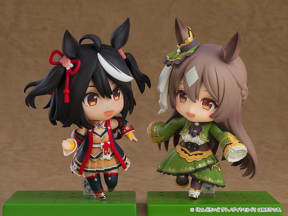 The 'Uma Musume: Pretty Derby Nendoroid No.2468 Kitasan Black' showcases the character in her racing-themed outfit with dynamic black hair decorated with floral accents and dual ponytails, complete with a joyful expression. The figure is set against a simple background, emphasizing its vibrant color scheme and playful design.
