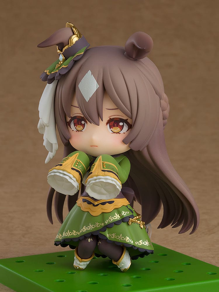 The 'Uma Musume: Pretty Derby Nendoroid No.2469 Satono Diamond' figure features the character in a detailed, green and gold outfit with elements reflecting her horse-themed origins. She sports large brown pony ears, a playful expression, and accessories that enhance her adorable, chibi-style form.
