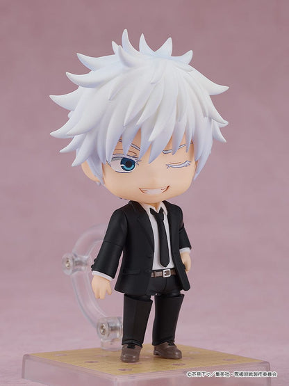 The image shows a Nendoroid of Satoru Gojo from "Jujutsu Kaisen" dressed in a suit. He's striking a confident pose with sunglasses and a scroll stand accessory.