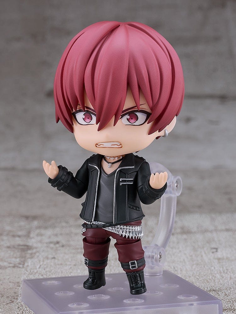 IDOLiSH7 Nendoroid Toma Inumaru figure featuring a black jacket, burgundy pants, and confident pose with interchangeable faceplates, set against a textured gray background.