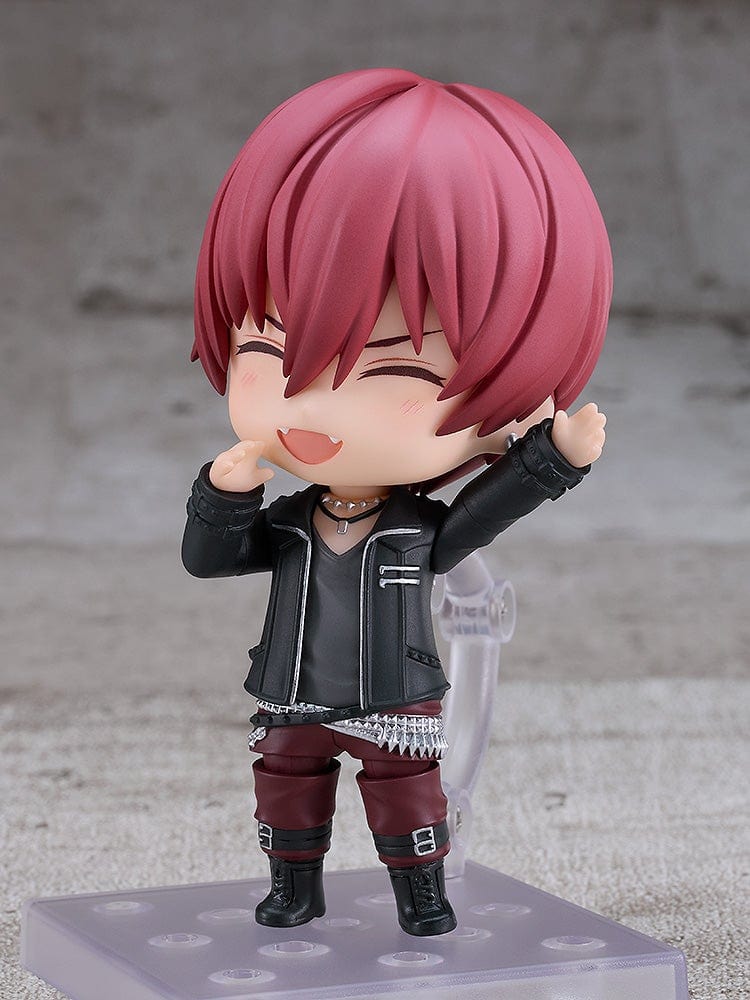 IDOLiSH7 Nendoroid Toma Inumaru figure featuring a black jacket, burgundy pants, and confident pose with interchangeable faceplates, set against a textured gray background.