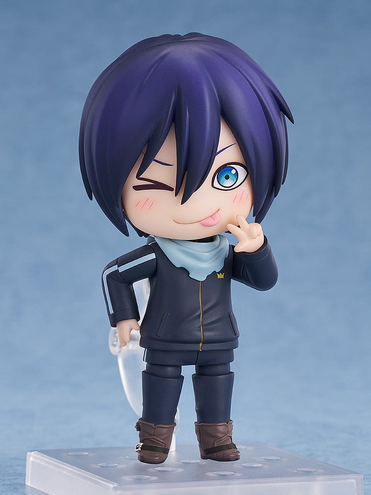 Noragami Nendoroid No.2565 Yato in his iconic dark tracksuit with blue scarf, smiling confidently.