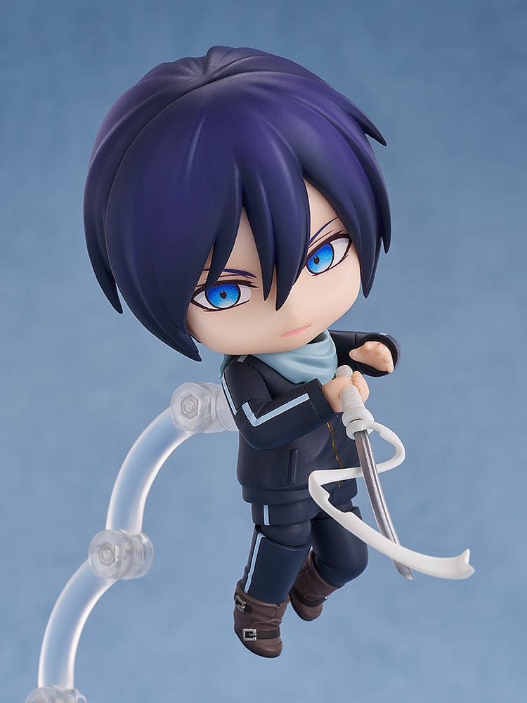 Noragami Nendoroid No.2565 Yato in his iconic dark tracksuit with blue scarf, smiling confidently.