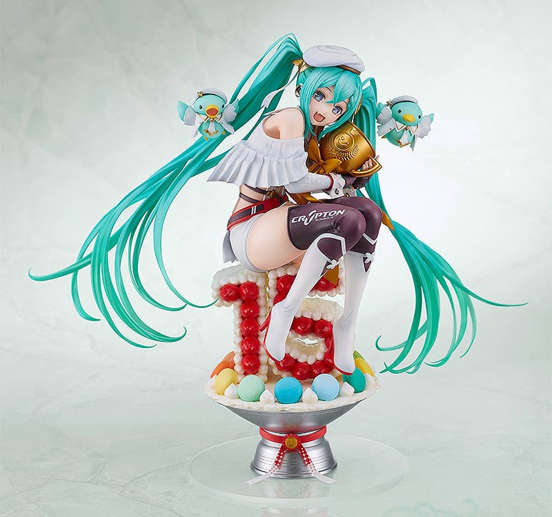 Hatsune Miku GT Project Racing Miku 2023 (15th Anniversary Ver.) 1/6 Scale Figure, posed on a dessert-like pedestal, featuring Miku in her race queen attire with festive teal hair and accompanied by miniature pit crew mascots, celebrating her 15th year in the spotlight.