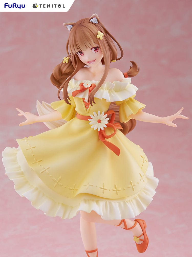 Spice and Wolf Tenitol Holo figure, featuring Holo in a joyful pose wearing a flowing yellow dress with wolf ears and tail, standing on a decorative base.