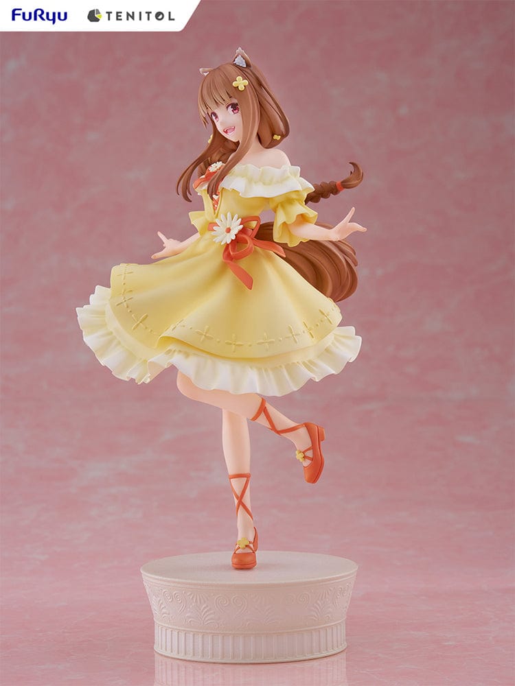 Spice and Wolf Tenitol Holo figure, featuring Holo in a joyful pose wearing a flowing yellow dress with wolf ears and tail, standing on a decorative base.