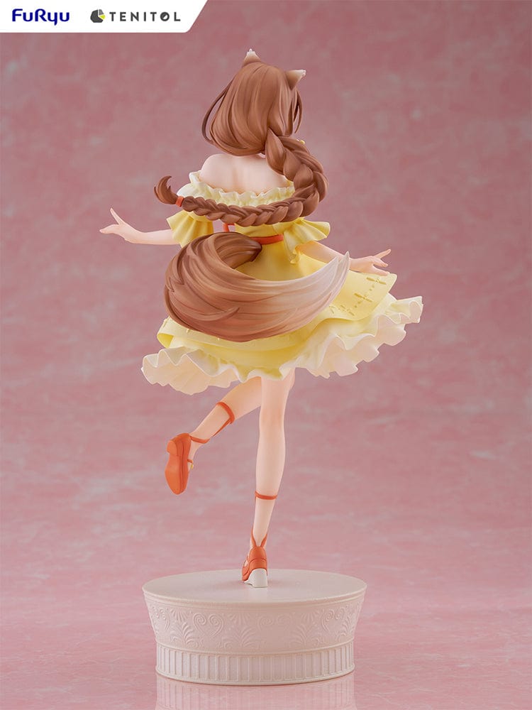 Spice and Wolf Tenitol Holo figure, featuring Holo in a joyful pose wearing a flowing yellow dress with wolf ears and tail, standing on a decorative base.