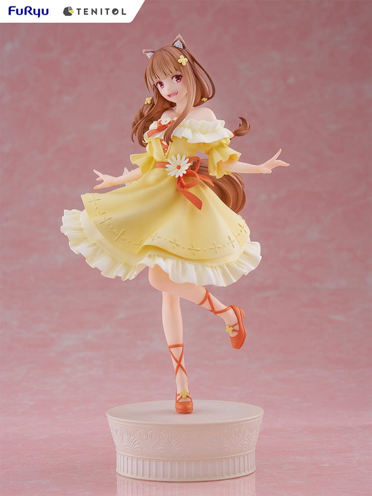 Spice and Wolf Tenitol Holo figure, featuring Holo in a joyful pose wearing a flowing yellow dress with wolf ears and tail, standing on a decorative base.