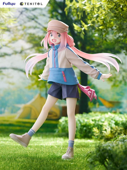 Laid-Back Camp Tenitol Nadeshiko Kagamihara Figure - Animated figure of Nadeshiko in a joyful pose with pink hair and cap, wearing a blue and pink outdoor outfit, on a grass-textured base.
