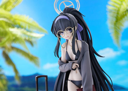 Blue Archive Ui (Swimsuit) 1/7 Scale Figure featuring Ui in a black swimsuit with an oversized jacket, long black hair, and detailed beach base with suitcase and stone pillar.