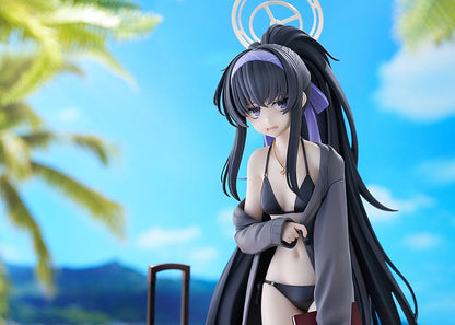 Blue Archive Ui (Swimsuit) 1/7 Scale Figure featuring Ui in a black swimsuit with an oversized jacket, long black hair, and detailed beach base with suitcase and stone pillar.